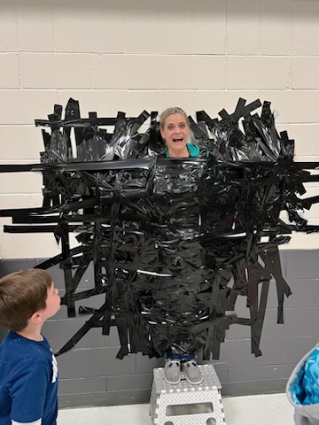 Mrs. Ingram taped to the wall for the Chocolate Fundraiser Celebration Assembly