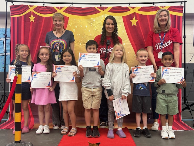 Kindergarten teachers and students posing for the Patriot Power awards for kindness and achievement.