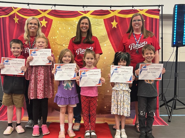 First grade students and teachers posing for their Patriot Power awards for kindness and achievement.